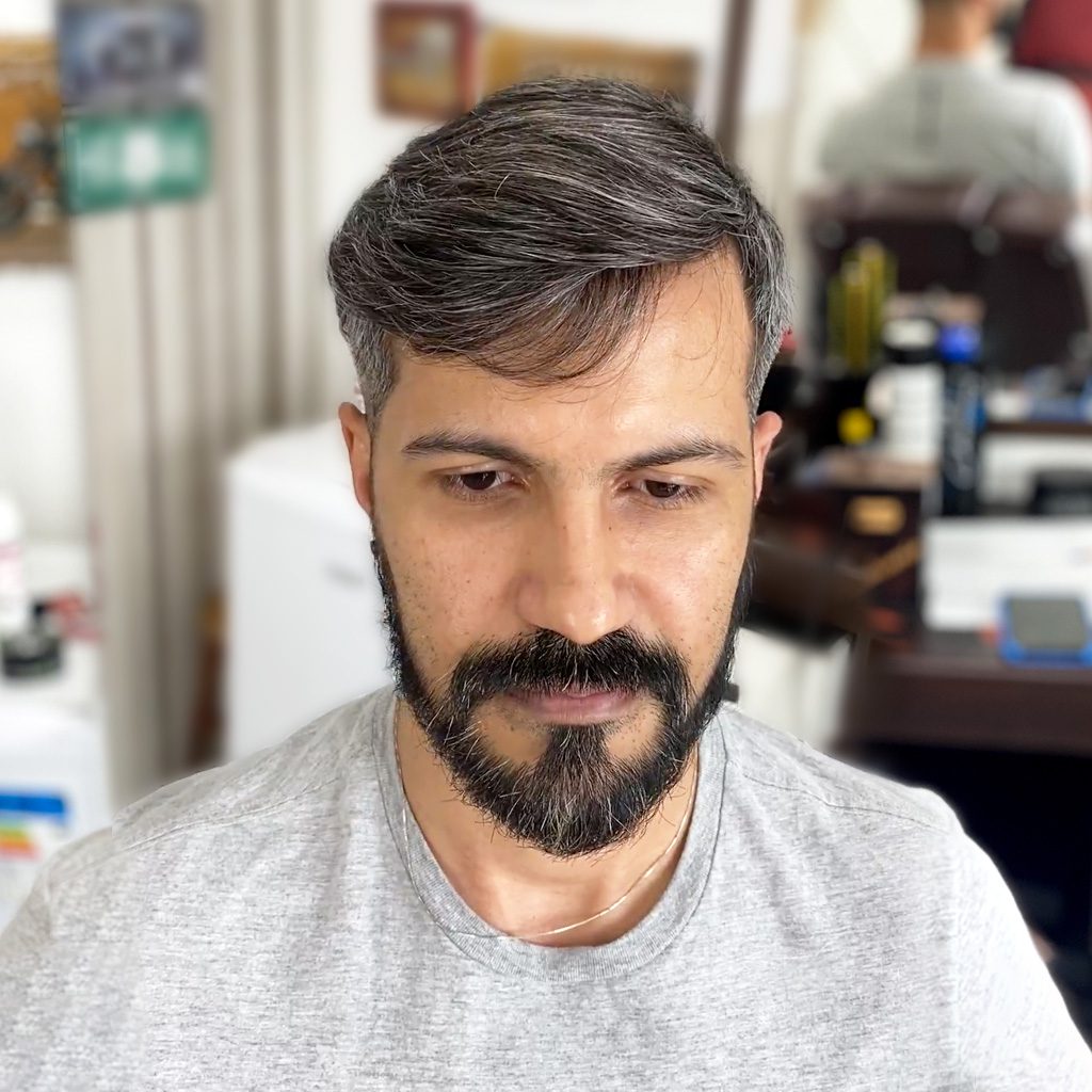A man with a beard and mustache in front of a mirror.