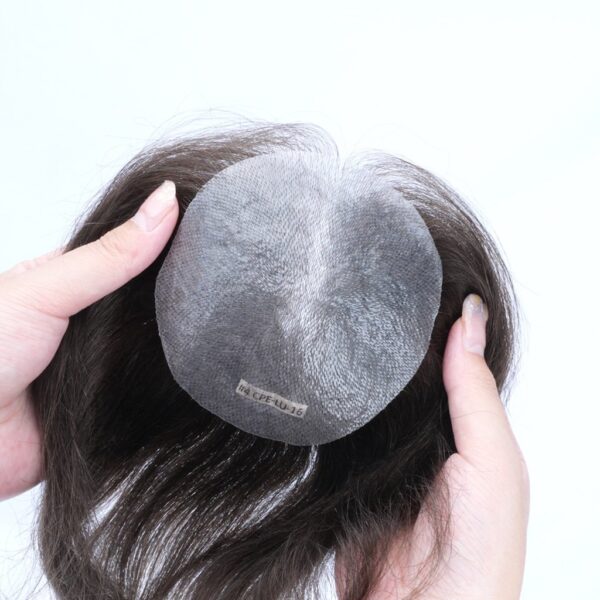 A person holding a hair piece in their hands.