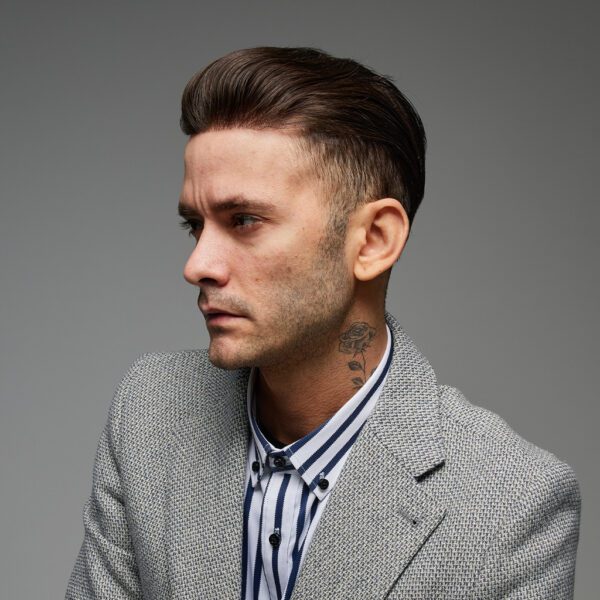 A man with a suit and striped shirt on.