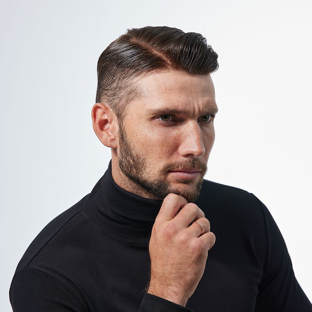 A man with a beard and mustache is looking at the camera.