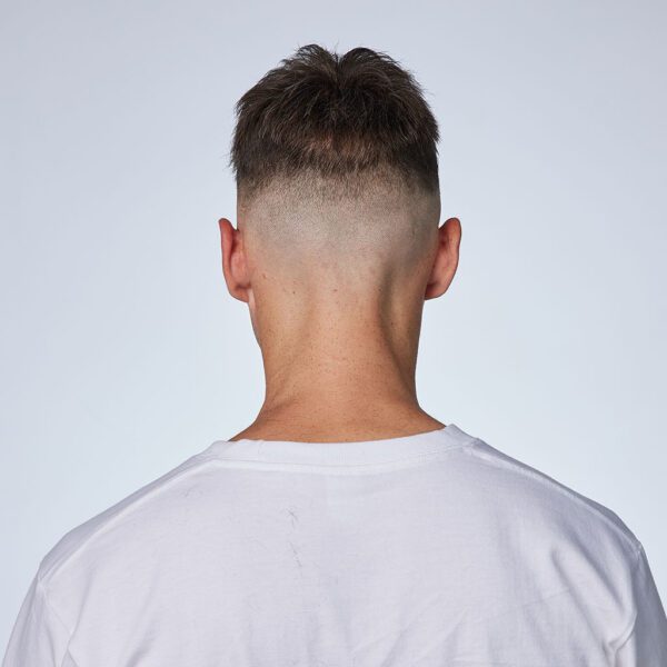 A man with a shaved head and a white shirt