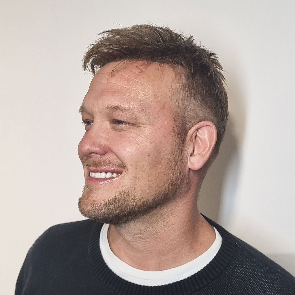 A man with a beard and smiling.