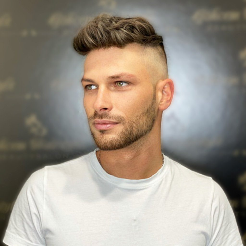 A man with a shaved head and beard.